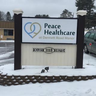 A sign for Peace Healthcare in a snowy outdoor setting.