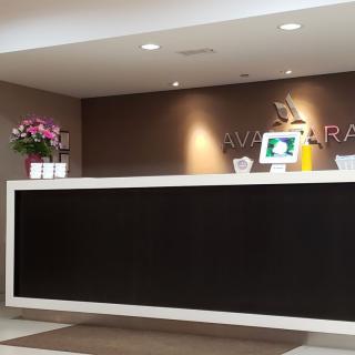 Modern office reception area with a sleek desk and decorative flowers.