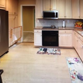 A modern kitchen with stainless steel appliances and wooden cabinetry.