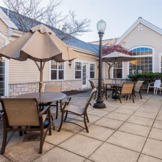 Outdoor patio area with tables and chairs under umbrellas.