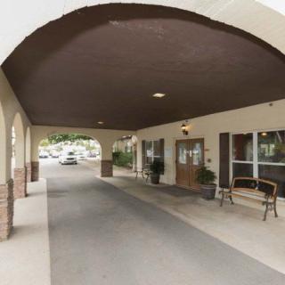 A covered driveway entrance to a building with outdoor seating.