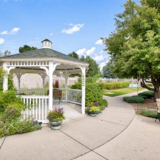 A serene garden scene with a white gazebo and winding pathway.