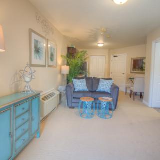 A cozy living room with a blue sofa, complemented by light walls and decorative elements.