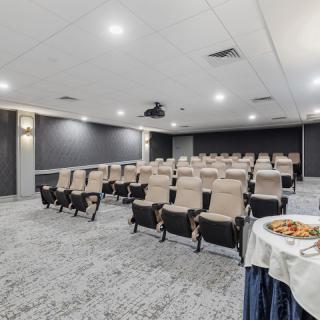 A small auditorium with theater-style seating and a table of snacks in the foreground.