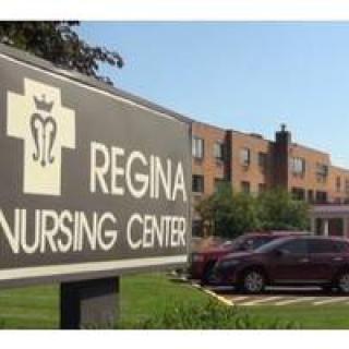 A sign for Regina Nursing Center in front of the facility building.