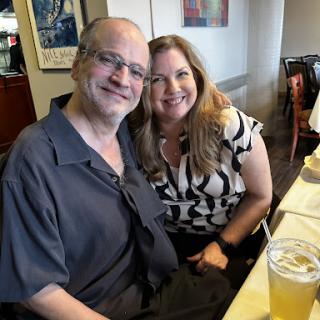 A joyful moment shared between two friends at a restaurant.