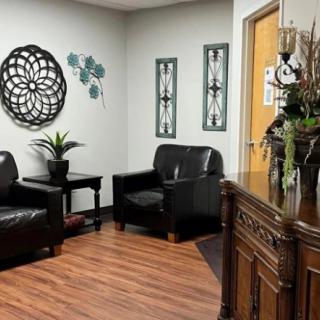 A cozy waiting room with leather chairs and decorative wall art.