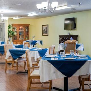 A cozy dining area with neatly arranged tables, featuring blue and white table settings.