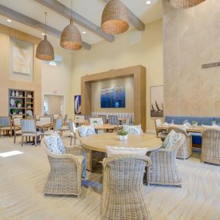 A modern and stylish lounge area with wicker chairs and pendant lighting.
