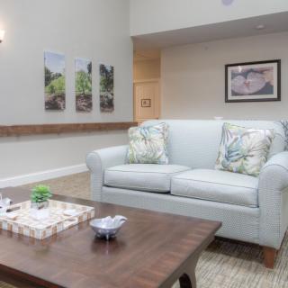 A cozy living room with a comfortable sofa, a wooden coffee table, and decorative artwork on the walls.