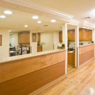A spacious and modern office reception area with wood flooring and ample lighting.