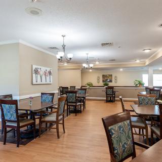 A spacious dining area with tables and chairs, decorated with artwork and lighting fixtures.