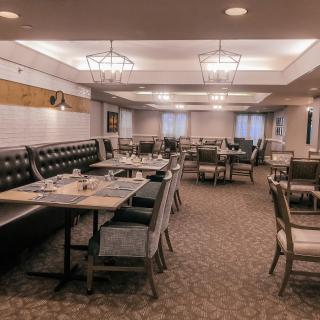 An empty restaurant dining area with neatly arranged tables and chairs.