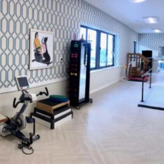 A well-equipped therapy room with exercise machines and rehabilitation tools.