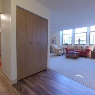 Spacious living room with large windows and wooden flooring.