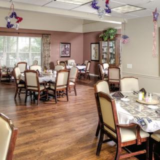 An elegant dining room with tables and chairs, decorated for an event.