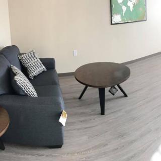 A modern living room with a dark sofa, round coffee table, and contemporary decor.
