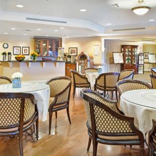 An elegant dining area with neatly arranged tables and chairs, featuring warm lighting and tasteful decor.