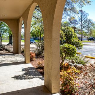 A serene porch view surrounded by lush greenery and well-maintained landscaping.