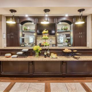 A beautifully designed modern kitchen featuring dark wood cabinetry, elegant lighting, and decorative elements.