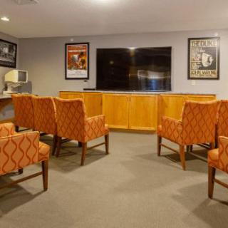 A cozy entertainment room with comfortable seating and a large television.