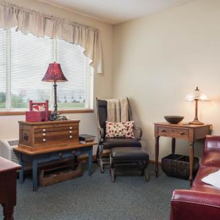A cozy living room with wooden furniture and a large window.