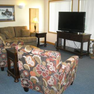 Cozy living room with a comfortable sofa, floral armchairs, and a flat-screen TV.