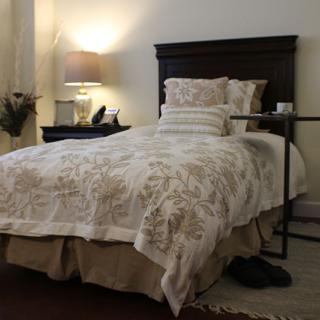 A cozy bedroom with a neatly made bed and warm lighting.