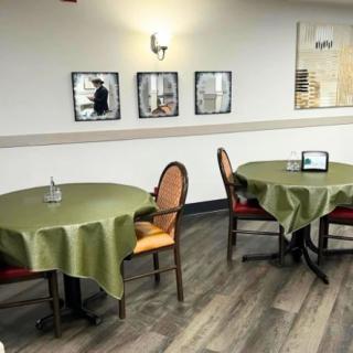 A cozy dining area with green tablecloths and elegant decor.
