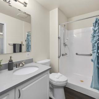 A sleek and modern bathroom featuring a shower, sink, and tasteful decor.