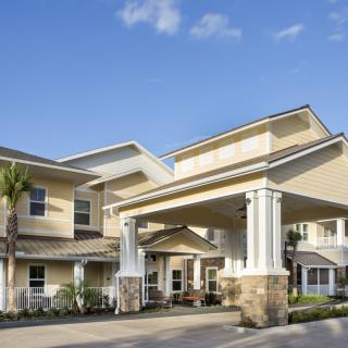 A modern residential building with a grand entrance and covered walkway.
