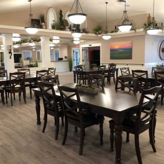 A spacious dining room with neatly arranged tables and chairs, elegant lighting fixtures, and tasteful decor.