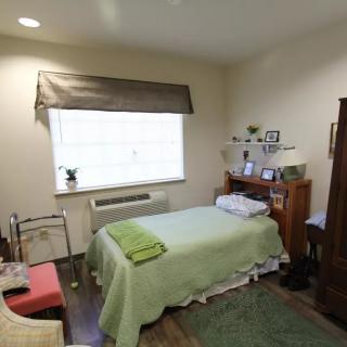 A cozy bedroom with a single bed and various furniture pieces.