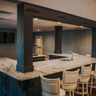 Modern home bar with a marble countertop and stylish seating.