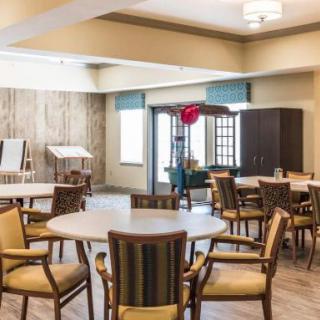 A well-lit meeting room with multiple tables and chairs arranged for a gathering.