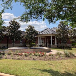 A landscaped area with a gazebo and fountain surrounded by trees.