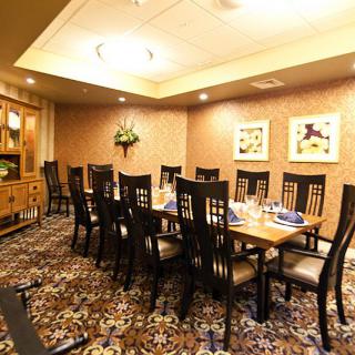An elegantly decorated dining room with a large table and chairs, ready for a gathering.