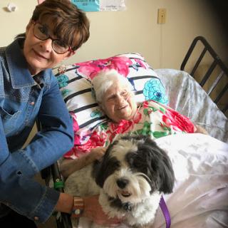 A loving companion visit at a care facility, brightening the day for both the resident and her visitor.