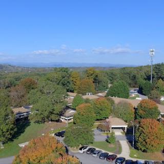 A scenic view of a park showcasing vibrant autumn foliage under a clear blue sky.