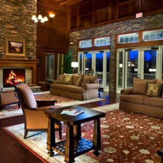 A cozy living room with a fireplace, comfortable seating, and elegant decor.