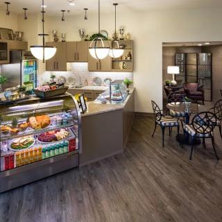 A modern kitchen and cafe area with a counter display and seating arrangements.
