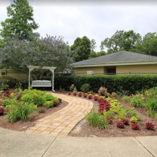 A beautifully landscaped garden with a winding pathway, lush greenery, and vibrant flowers.