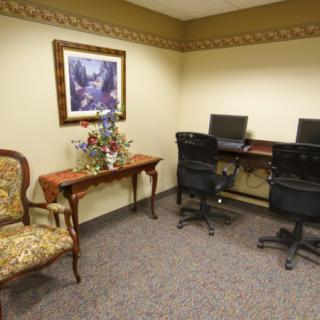 A small office space with computers, chairs, and decorative furniture.