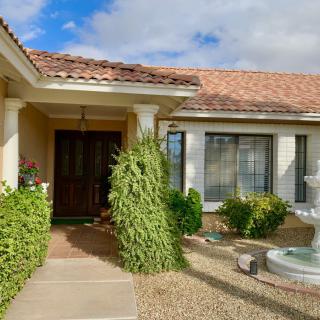 The entrance of a house with a fountain and landscaped front yard.