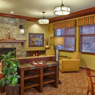 A cozy living room with a stone fireplace and comfortable seating arrangement.