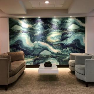 A modern living room with abstract artwork, comfortable seating, and stylish lighting.