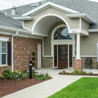 Front view of a modern house with brick exterior and landscaped walkway.