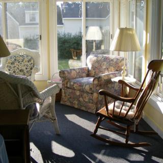 A cozy sunroom with comfortable seating and ample natural light.
