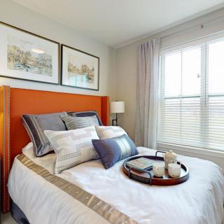 A cozy, well-decorated bedroom with an inviting bed and natural light.