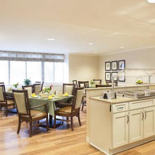 A spacious and modern kitchen and dining area with ample natural light and elegant furnishings.